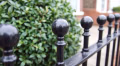 TF12 ball-top railings alongside a garden hedge