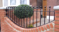TF12 ball-top railings on a curved red-brick garden wall