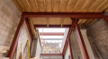 Red-oxide steel frame supporting a loft conversion, timber joists overhead