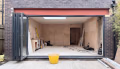 Red-oxide primed steel beam spanning a wide rear opening