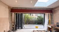 Red-oxide primed steel beam spanning a new bi-fold opening in a rear extension